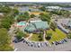 Wide aerial view showcasing community amenities including a pool, sports courts, parking, and lush green spaces at 17645 Se 117Th Cir, Summerfield, FL 34491