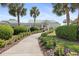 Inviting community center entrance with a landscaped walkway, mature palm trees, and well-maintained grounds at 17645 Se 117Th Cir, Summerfield, FL 34491