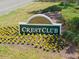 Landscaped community sign for Crest Club, adorned with vibrant yellow flowers and lush green foliage at 17645 Se 117Th Cir, Summerfield, FL 34491