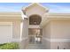 Inviting front entrance featuring a charming courtyard with white gates, a hanging light, and address numbers at 17645 Se 117Th Cir, Summerfield, FL 34491