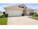 Charming one-story home with a well-maintained lawn, two-car garage, and beautifully manicured shrubs at 17645 Se 117Th Cir, Summerfield, FL 34491