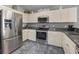 Stylish kitchen with stainless steel appliances, white cabinets, black granite countertops and tile floors at 17645 Se 117Th Cir, Summerfield, FL 34491