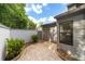 Enclosed patio with stone pavers, lush greenery, and a privacy wall, offering a peaceful outdoor space for relaxation and entertainment at 2042 Se 37Th Court Circle Cir, Ocala, FL 34471