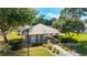 Pool house with metal roof surrounded by nice landscaping and walkway on a sunny day at 2042 Se 37Th Court Circle Cir, Ocala, FL 34471