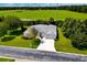 Aerial view of home featuring mature trees, green grass, and a driveway at 2358 Nw 59Th Ter, Ocala, FL 34482