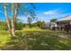 Backyard with a screened-in lanai, lush greenery, and a lawn at 2358 Nw 59Th Ter, Ocala, FL 34482