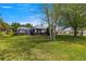 Large backyard featuring mature trees, green grass, and a screened-in lanai at 2358 Nw 59Th Ter, Ocala, FL 34482