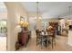 A cozy dining area features a wood table, chandelier, and a stylish buffet with decorative lamps and a mirror at 2358 Nw 59Th Ter, Ocala, FL 34482