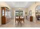 Bright dining room featuring a tray ceiling, classic chandelier, and serene views of the backyard at 2358 Nw 59Th Ter, Ocala, FL 34482