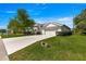 Charming single-story home featuring a well-manicured lawn, mature tree, and a two-car garage with light colored driveway at 2358 Nw 59Th Ter, Ocala, FL 34482