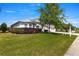 Charming single-story home featuring a well-manicured lawn, mature tree, and a two-car garage with light colored driveway at 2358 Nw 59Th Ter, Ocala, FL 34482
