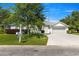 Charming single-story home featuring a well-manicured lawn, mature tree, and a two-car garage with light colored driveway at 2358 Nw 59Th Ter, Ocala, FL 34482