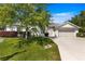 Charming single-story home featuring a well-manicured lawn, mature tree, and a two-car garage with light colored driveway at 2358 Nw 59Th Ter, Ocala, FL 34482