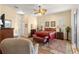 An inviting bedroom with a ceiling fan, comfortable seating, and a doorway to a bathroom, creating a relaxing retreat at 2358 Nw 59Th Ter, Ocala, FL 34482