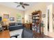 Inviting home office with a ceiling fan, large bookshelf, and comfortable seating area at 2358 Nw 59Th Ter, Ocala, FL 34482