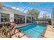 Relaxing pool area surrounded by mature trees and the home's covered patio at 2358 Nw 59Th Ter, Ocala, FL 34482