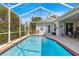 Sparkling swimming pool with a screened-in enclosure, surrounded by lush landscaping for ultimate privacy at 2358 Nw 59Th Ter, Ocala, FL 34482