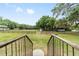 Expansive backyard with a wooden fence, lush greenery, and mature trees at 2720 Se 145Th St, Summerfield, FL 34491