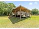 Spacious horse barn with a covered area for horse trailer parking on a well-maintained green lawn at 2720 Se 145Th St, Summerfield, FL 34491