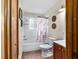 Cozy bathroom with a floral shower curtain, tub, and dark wood vanity at 2720 Se 145Th St, Summerfield, FL 34491