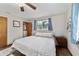Cozy bedroom featuring wood-look floors, a ceiling fan, and a bright window at 2720 Se 145Th St, Summerfield, FL 34491