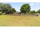 Exterior view of a home with a charming front porch, surrounded by a spacious fenced in yard at 2720 Se 145Th St, Summerfield, FL 34491