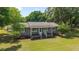 Attractive single-story home featuring a covered front porch and lush landscaping, nestled among mature trees at 2720 Se 145Th St, Summerfield, FL 34491
