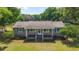 Charming single-story home featuring a covered front porch, green shutters, and a spacious green lawn at 2720 Se 145Th St, Summerfield, FL 34491