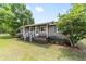 Cozy single-story home featuring a charming front porch with green shutters and well-maintained landscaping at 2720 Se 145Th St, Summerfield, FL 34491