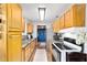 Well-lit kitchen featuring wood cabinets, mosaic tile backsplash, and modern appliances at 2720 Se 145Th St, Summerfield, FL 34491
