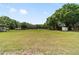 A view of a large grassy pasture with mature trees, a storage shed, and ample space at 2720 Se 145Th St, Summerfield, FL 34491