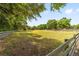 Scenic view of the property with lush green grass, mature trees, and covered area at 2720 Se 145Th St, Summerfield, FL 34491