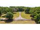 Expansive property featuring a long driveway, lush trees, and green pastures at 2720 Se 145Th St, Summerfield, FL 34491