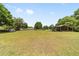 Expansive grassy yard featuring a barn, shed, and a charming single-story home in a serene setting at 2720 Se 145Th St, Summerfield, FL 34491