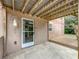 Covered back patio features a concrete pad, light fixture and door to the home's interior at 2800 Sw 141St Ct, Ocala, FL 34481
