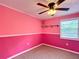 Bedroom with carpet, shelving, bright pink paint, and a ceiling fan at 2800 Sw 141St Ct, Ocala, FL 34481
