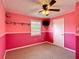 Bedroom with carpet, ceiling fan, window, and brightly painted pink walls at 2800 Sw 141St Ct, Ocala, FL 34481