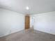 Carpeted bedroom features white walls, a ceiling light, and a wooden door at 2800 Sw 141St Ct, Ocala, FL 34481