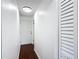 Hallway with wood-look floors, white paneled walls, and a flush mount ceiling light at 2800 Sw 141St Ct, Ocala, FL 34481