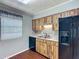 This kitchen features wood-look cabinets, a stainless steel sink, and a modern, black refrigerator at 2800 Sw 141St Ct, Ocala, FL 34481