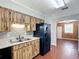 A kitchen featuring light countertops, wood-look cabinets, and a black refrigerator at 2800 Sw 141St Ct, Ocala, FL 34481