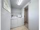 Functional laundry room featuring washer, dryer, and tile flooring for easy maintenance at 2800 Sw 141St Ct, Ocala, FL 34481