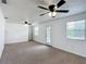 Spacious living room with neutral carpet, white walls, ceiling fans, and natural light at 2800 Sw 141St Ct, Ocala, FL 34481
