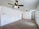 Spacious living room with neutral carpet, white walls, ceiling fans, and a glass exterior door at 2800 Sw 141St Ct, Ocala, FL 34481