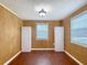 Room featuring wood paneling, two closets, and two windows providing natural light at 2800 Sw 141St Ct, Ocala, FL 34481