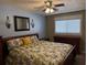 Comfortable bedroom features a floral bedspread, ceiling fan, and window with blinds at 3021 Se 5Th Ter # A, Ocala, FL 34471
