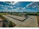 Inviting bocce ball court area with seating, lush landscaping, and lake views in a golf community at 4945 Nw 35Th Lane Rd, Ocala, FL 34482