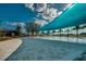 Resort-style community pool area featuring a shade structure, palm trees, and comfortable lounge chairs at 4945 Nw 35Th Lane Rd, Ocala, FL 34482