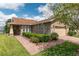 Charming single-story home featuring a stone-accented facade, lush landscaping, and a brick-paved driveway and walkway at 4945 Nw 35Th Lane Rd, Ocala, FL 34482
