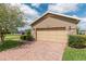 Close-up of a home's garage, showcasing stone accents, and a brick-paved driveway at 4945 Nw 35Th Lane Rd, Ocala, FL 34482